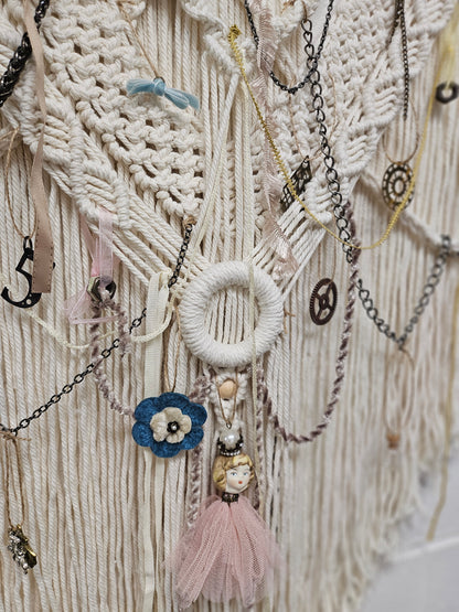 Hopes, Dreams, and Nightmares by Angel Singh is a hauntingly beautiful mixed-media art installation featuring a decorated deer skull suspended in intricate macramé. Symbolizing life, death, and rebirth, this 3&