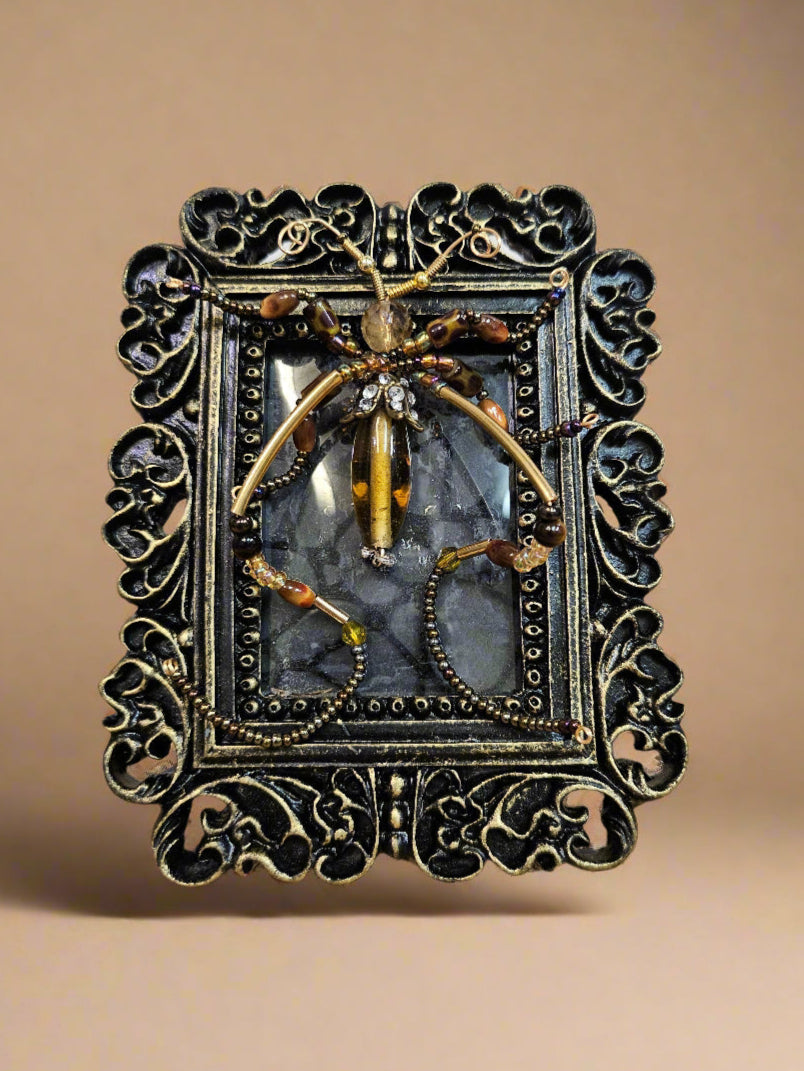 Jeweled Insect and Creature Art in Small Frame by KStonely (Kathy Epperley) is a celebration of nature’s elegance and meticulous craftsmanship. This 3D artwork captures the essence of KStonely’s artistry, merging intricate beadwork with an ethereal, whimsical touch.