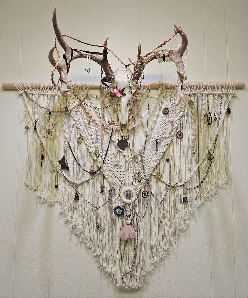 Hopes, Dreams, and Nightmares by Angel Singh is a hauntingly beautiful mixed-media art installation featuring a decorated deer skull suspended in intricate macramé. Symbolizing life, death, and rebirth, this 3&