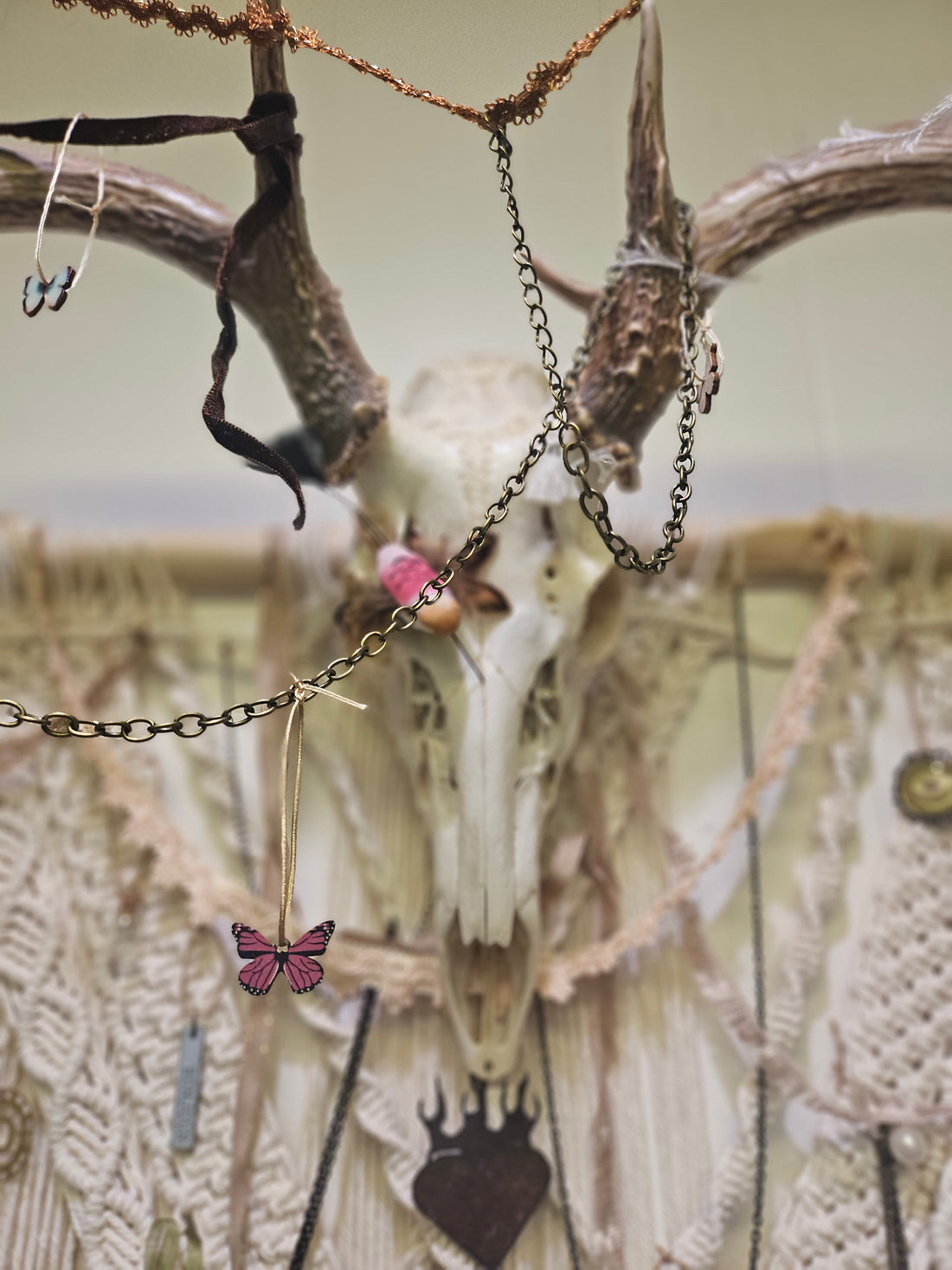 Hopes, Dreams, and Nightmares by Angel Singh is a hauntingly beautiful mixed-media art installation featuring a decorated deer skull suspended in intricate macramé. Symbolizing life, death, and rebirth, this 3&