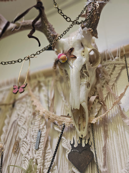 Hopes, Dreams, and Nightmares by Angel Singh is a hauntingly beautiful mixed-media art installation featuring a decorated deer skull suspended in intricate macramé. Symbolizing life, death, and rebirth, this 3&