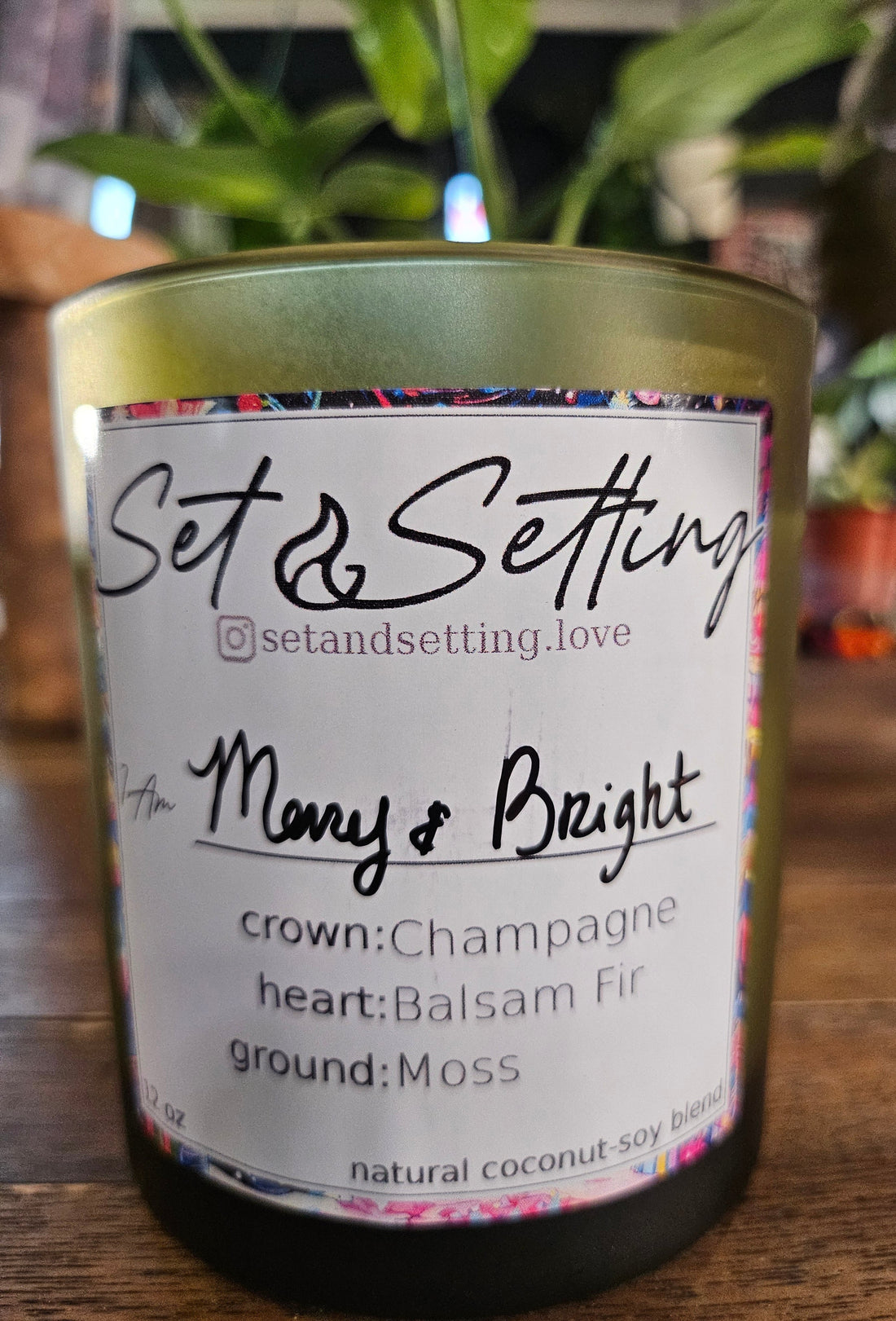 Merry and Bright 12oz Candle by Set &amp; Setting Love features a festive blend of champagne, balsam fir, and moss in an elegant evergreen glass jar. Made with a natural coconut-soy wax blend, it offers a cleaner, longer burn. Perfect for celebrations, self-care, and gifting, it adds warmth and luxury to any space.