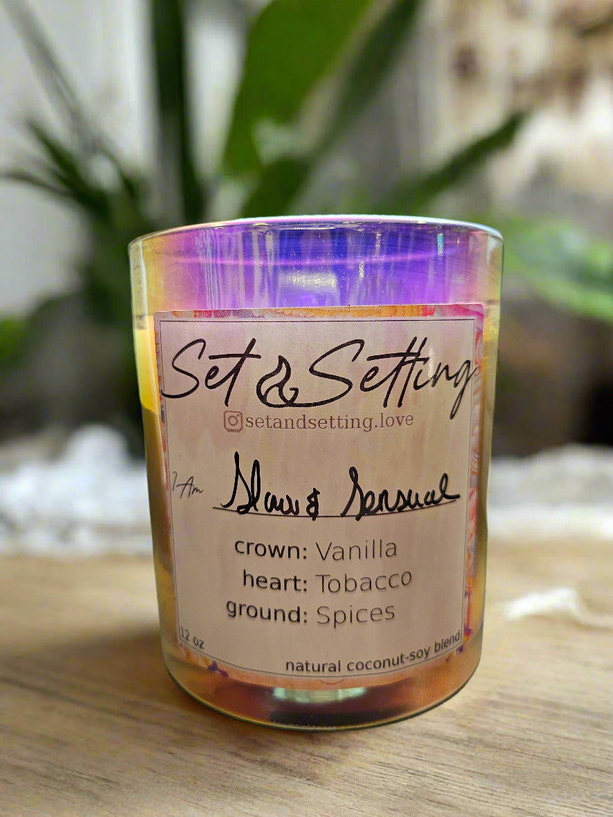 Slow &amp; Sensual 12oz Candle by Set &amp; Setting Love features a rich blend of vanilla, tobacco, and spices in an iridescent glass jar. Made with a natural coconut-soy wax blend, it offers a clean, eco-friendly burn. Perfect for romantic evenings, self-care, and gifting, it creates a warm, intimate ambiance.