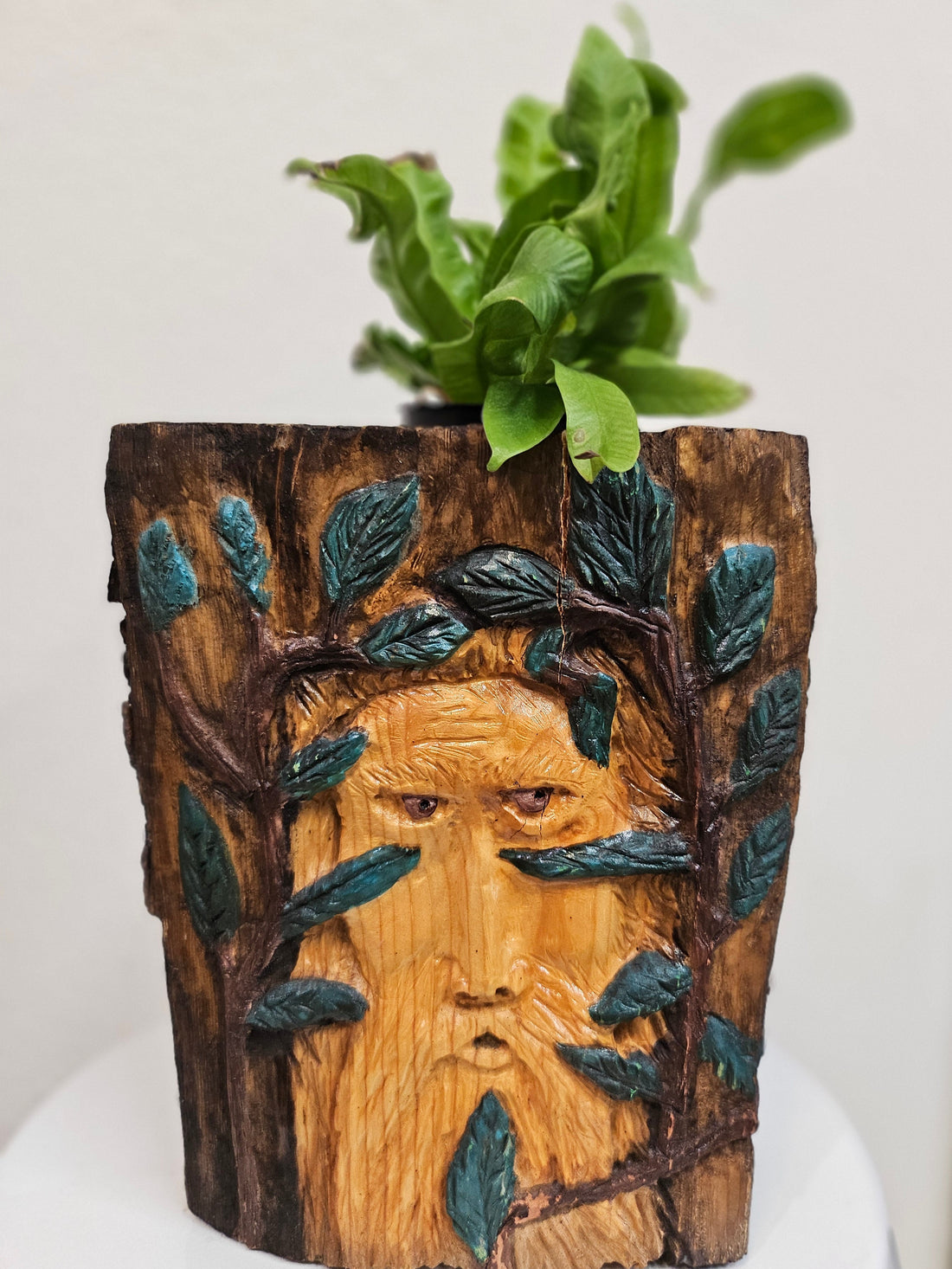 This Hand-Carved &amp; Painted Wood Spirit Planter in solid walnut features intricate details and black-painted accents. 100% handmade, each piece is unique and perfect for home decor or garden. The natural walnut grain and artisanal craftsmanship add rustic charm, making it a standout decorative piece for any space.